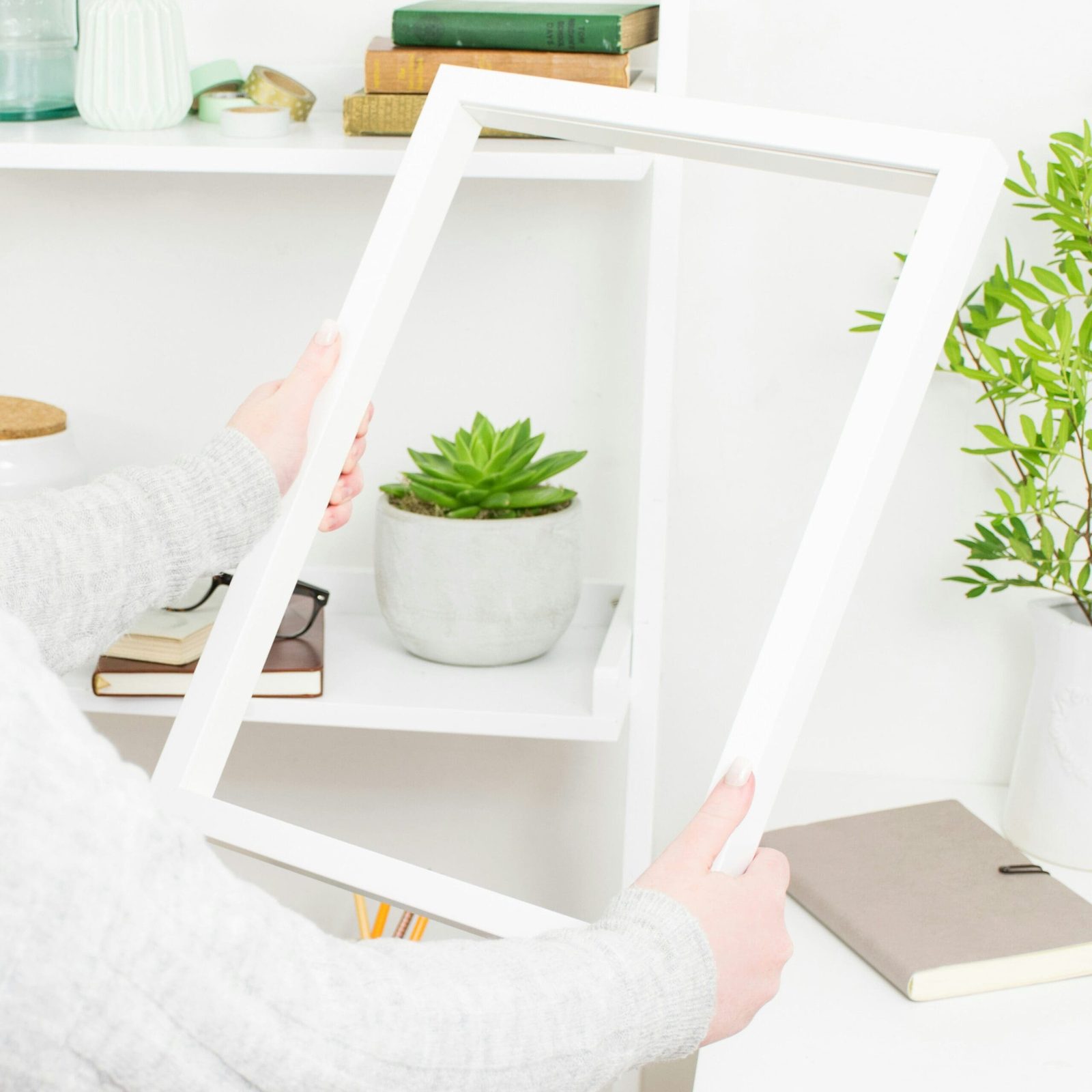 Health practitioner setting up a home office workspace with greenery and books for an online practice