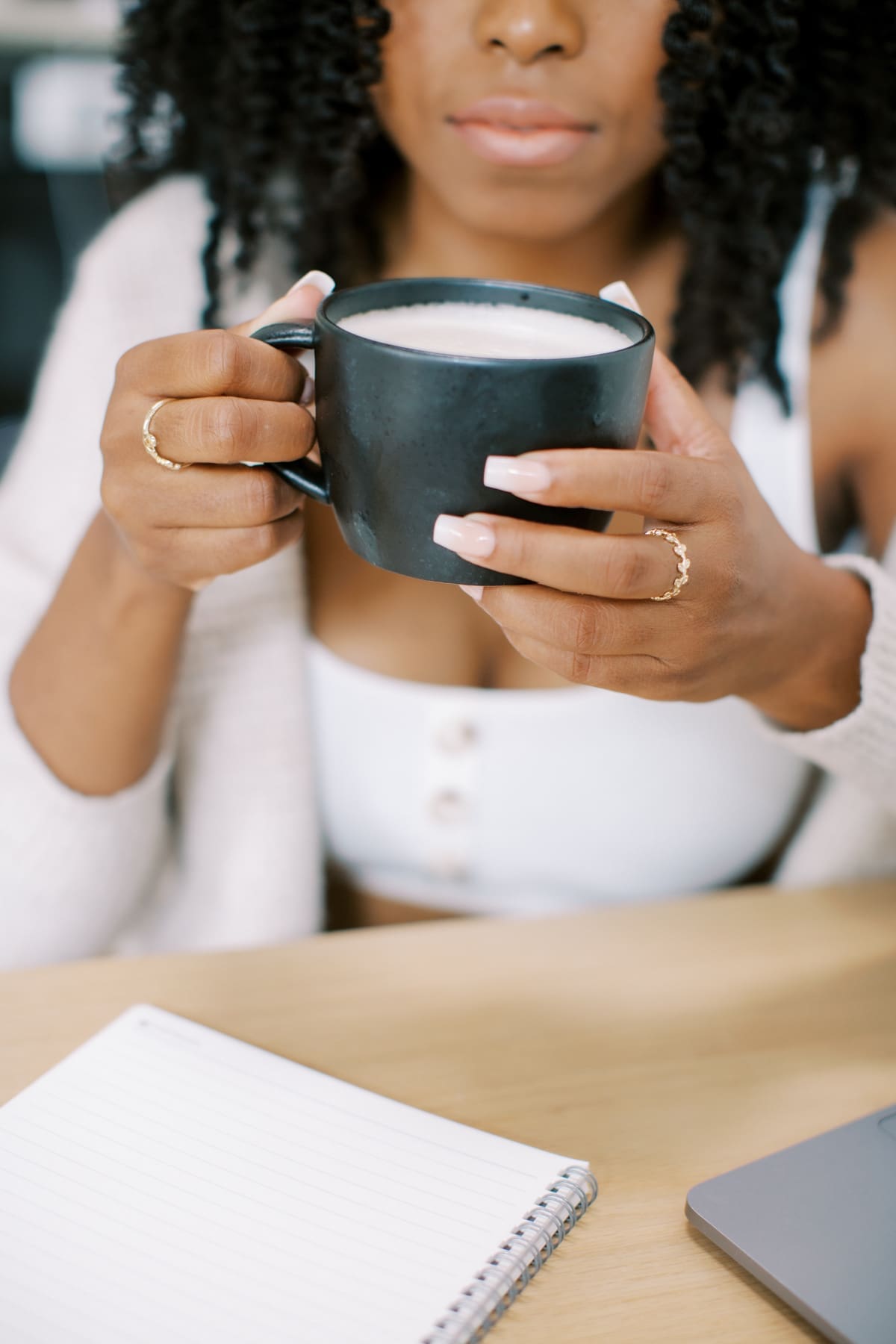 an online health practitioner drinking a cup of coffee with her planner open  using tools of how to stop procrastinating