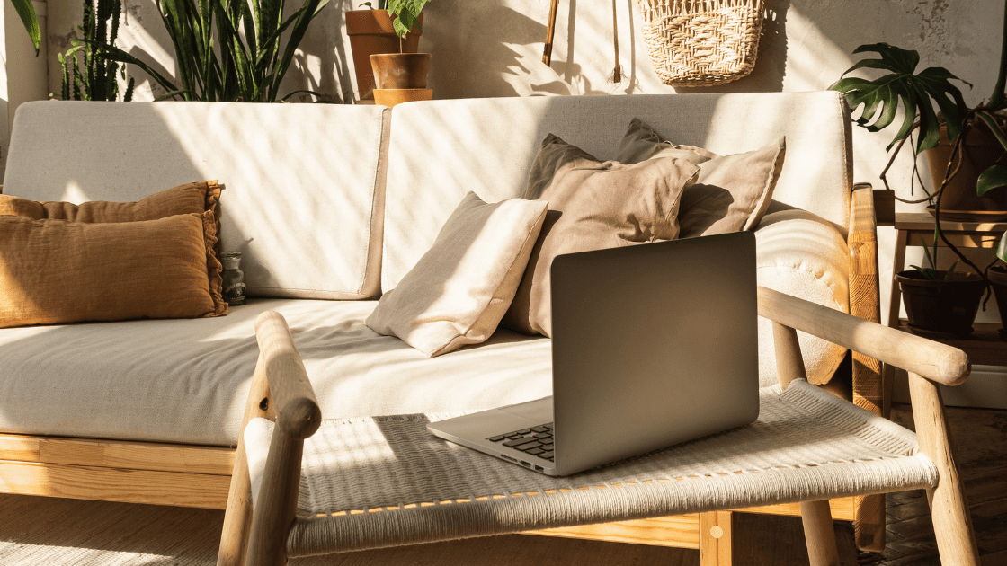 Laptop on sofa in bright home office, symbolizing online health coaches building client connections
