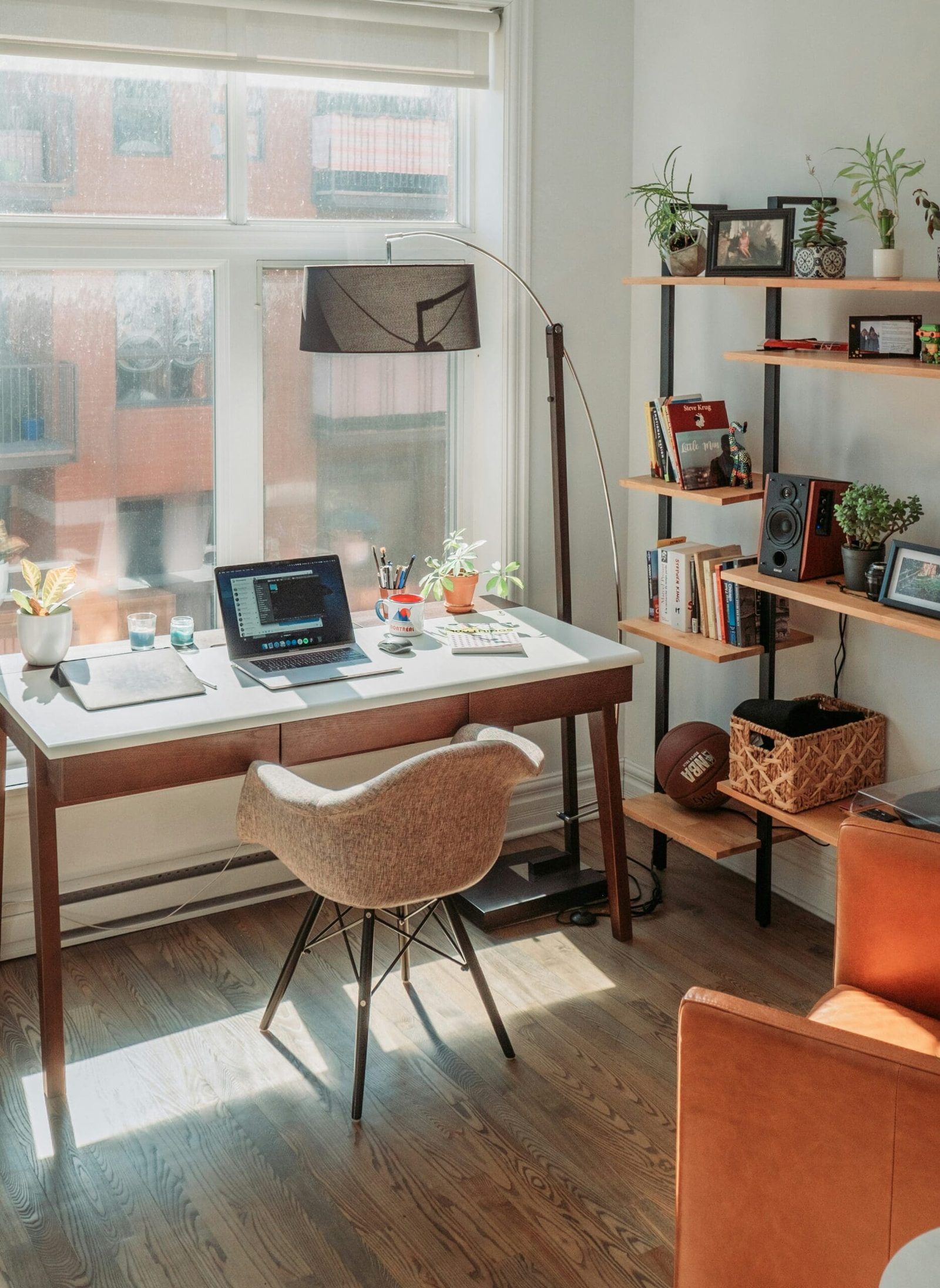 Sunlit home office setup with laptop and plants representing the freedom and flexibility of running a virtual wellness business.