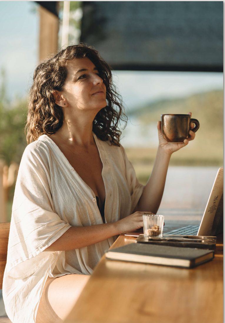 Michelle at her desk with a coffee, smiling