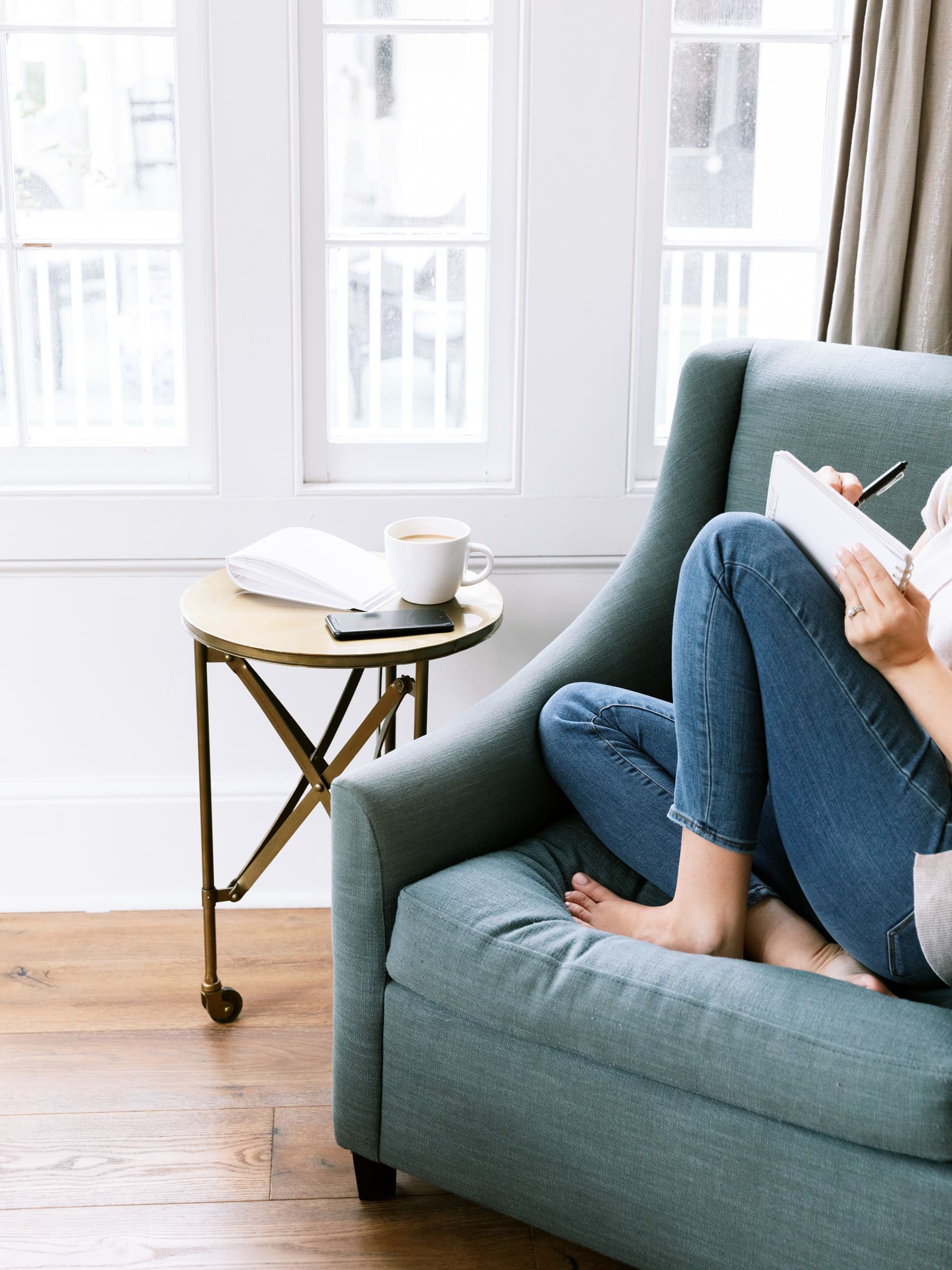 woman sitting on the couch with her notebook writing ideas how to grow an online health practice