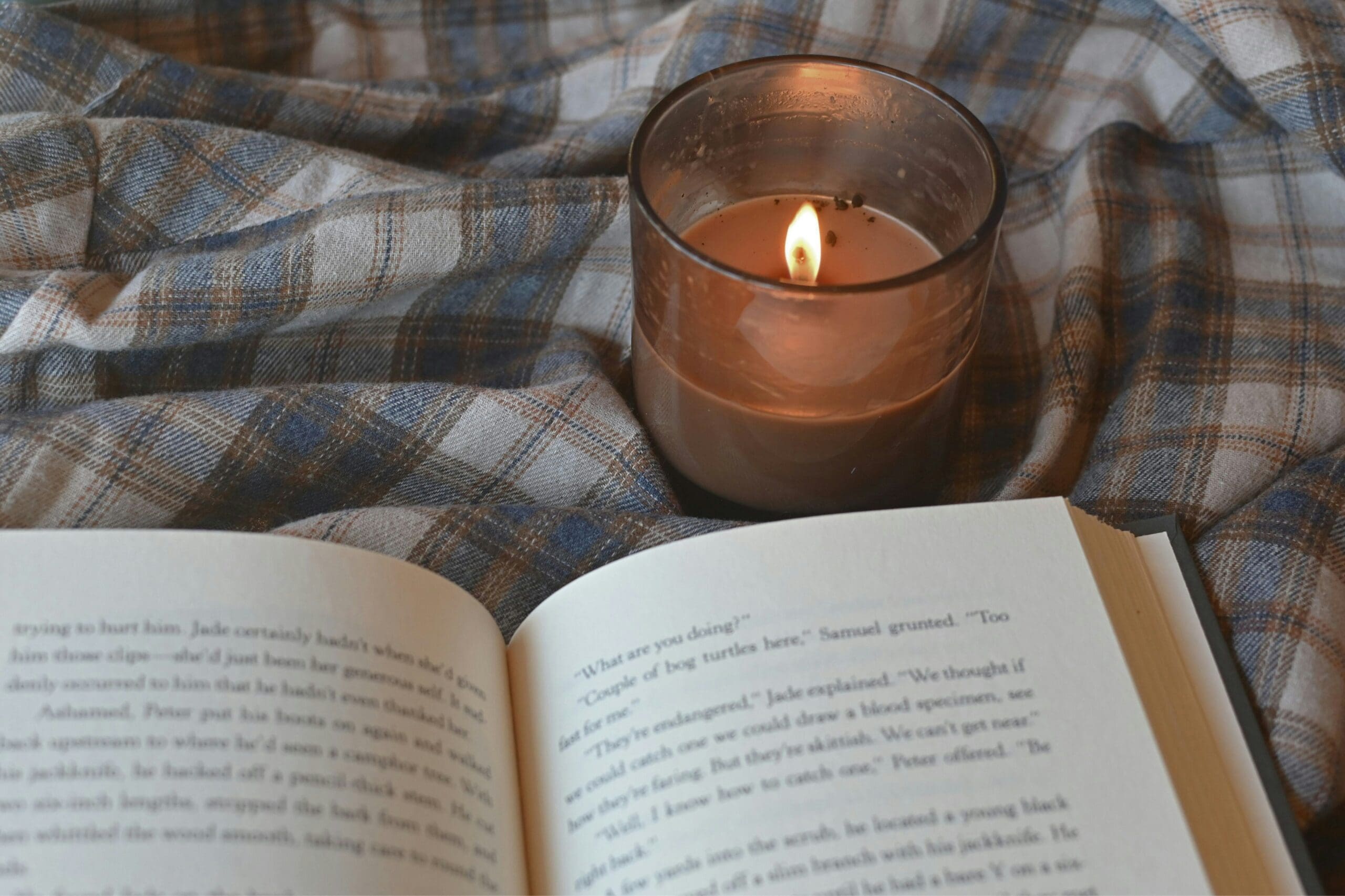Relaxing evening with candlelight and a book – illustrating rest and avoiding burnout as a practitioner.