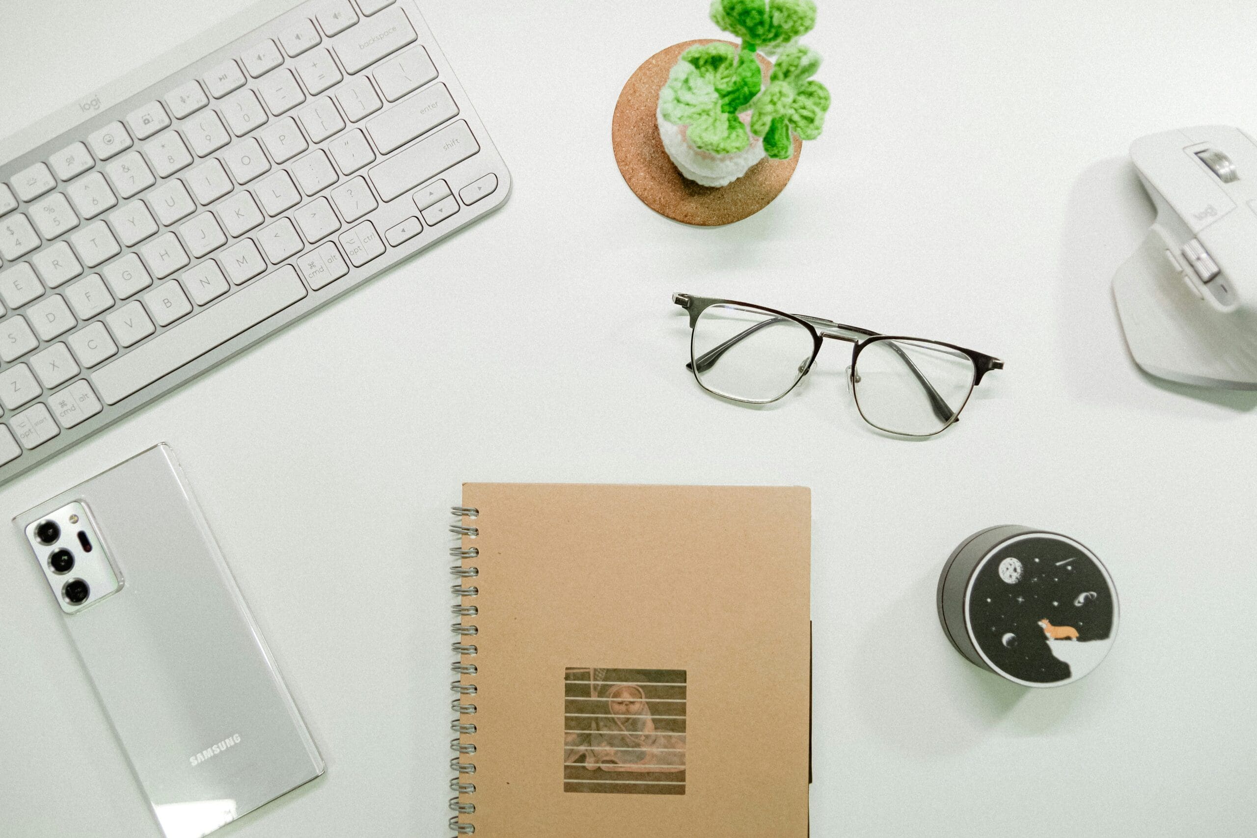 Workspace with notebook and glasses, representing clarity and focus in health practitioners’ content creation.