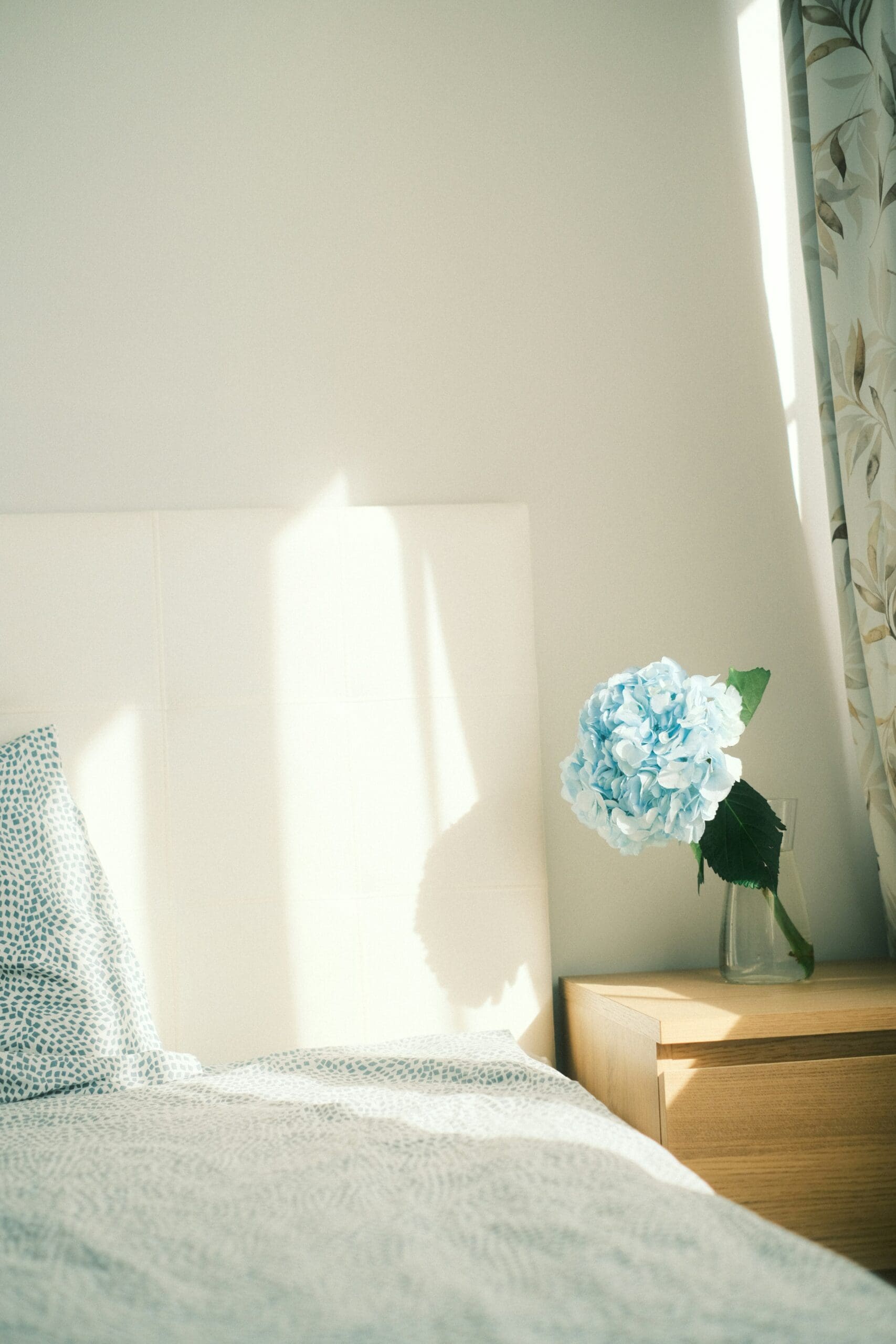 Simple bedroom with fresh flowers – reflecting peace, fulfillment, and lifestyle freedom in business.