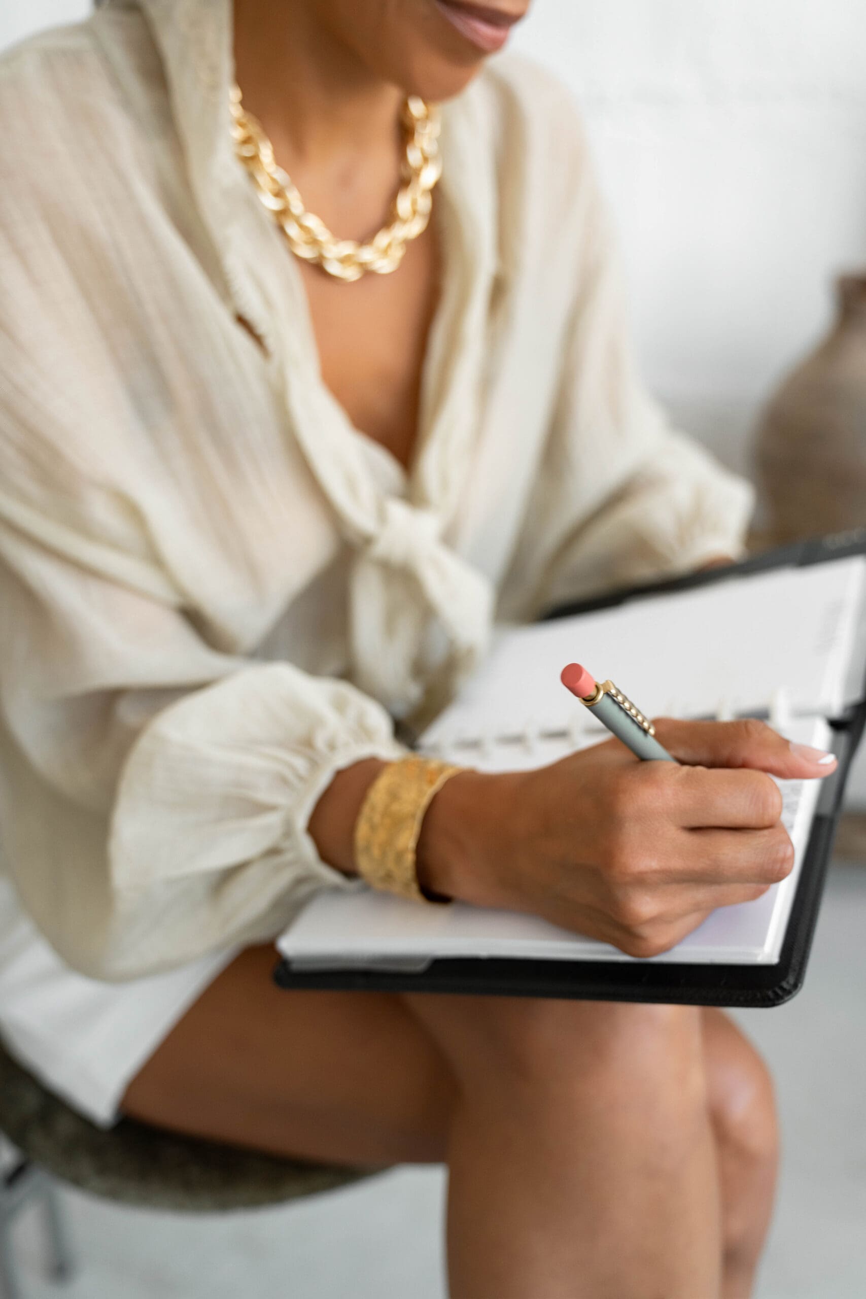 an online health practitioner writing a schedule in her planner after learning how to stop procrastinating